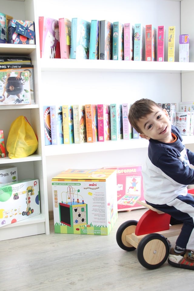 boy on tricycle riding in a new toy store